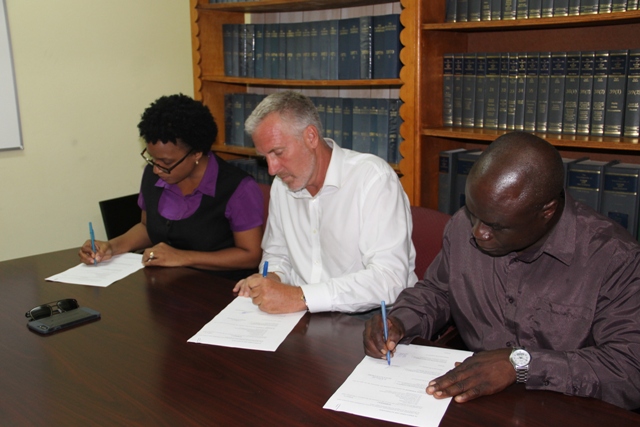 (L-r) Permanent Secretary in the Ministry of Health Nicole Slack-Liburd, Representative for ENCLAVE Resources Geoffrey Folsom and Manager of the Nevis Solid Waste Management Authority Andrew Hendrickson sign agreement for disposal of waste metal and cardboard on Nevis at a ceremony at the Legal Department’s conference room on July 17, 2017